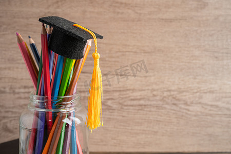毕业帽与彩色铅笔与复制空间，学习大学教育理念。