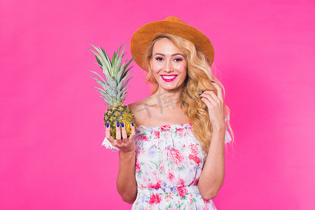幸福的女人和菠萝在粉红色背景下的画像。