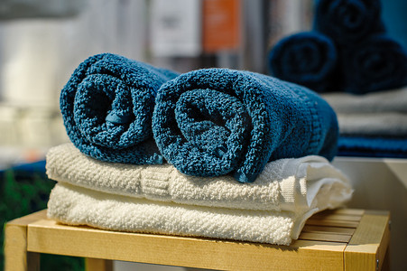 四套不同颜色的干净柔软双人浴巾叠放在木椅上