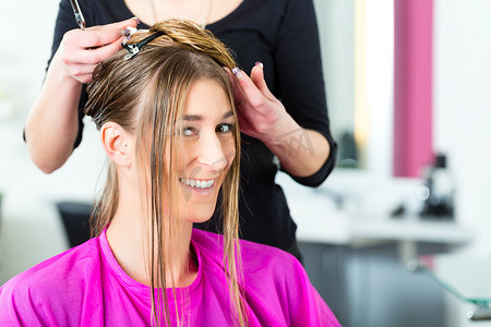 理发造型摄影照片_从发型师或美发师那里接受理发的妇女