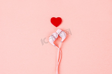 有红色心脏的耳机在桃红色背景。