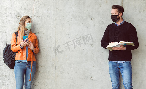大学校园安全摄影照片_两名戴着口罩站在社交距离上的学生