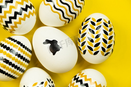 白色背景上带有金色和黑色几何图案的白色鸡蛋。