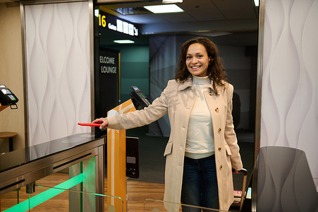 美女乘客在进入机场出发航站楼的贵宾休息室时，将手机放在扫描仪上，在值机柜台读取二维码，扫描手机上的信息