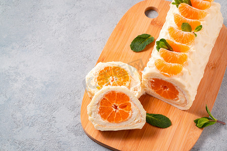 霜果实摄影照片_甜蛋糕卷配鲜奶油和橘子馅