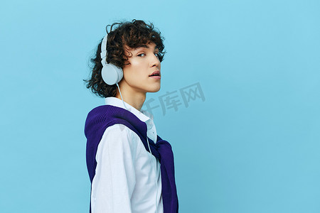 蓝色白背景科技摄影照片_身着白衬衫和毛衣的男士科技耳机 Lifestyle school