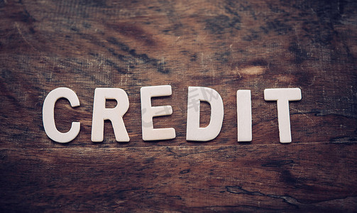 credit摄影照片_“CREDIT”一词是由放在 w 上的木制字母排列而成