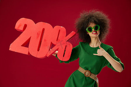 美容时尚女性绿色连衣裙爆炸头发型墨镜百分之二十在手颜色背景不变