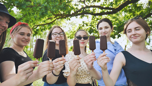 女朋友们把巧克力冰淇淋连续放在一根棍子上。