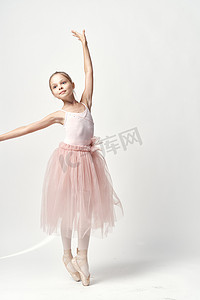 穿着粉红色舞蹈服装芭蕾舞足尖鞋芭蕾舞短裙浅色背景模型的女孩芭蕾舞演员