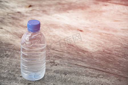木桌纹理上的塑料水瓶。