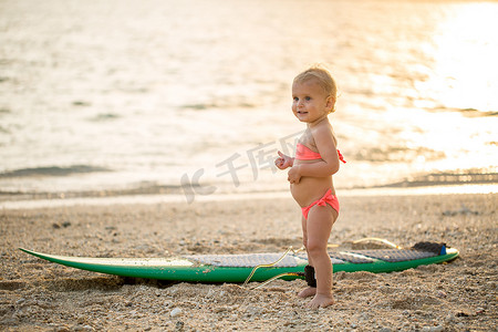 冲浪海上摄影照片_一个小女孩学会在海上冲浪。