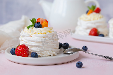 霜果实摄影照片_蛋白酥皮、巴甫洛娃蛋糕配草莓、蓝莓和薄荷
