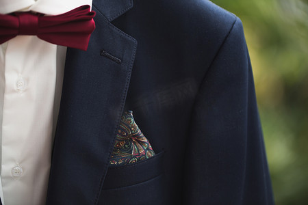 西装和领带摄影照片_优雅的正式西装特写，深灰色夹克，口袋衬衫和领带上有手帕