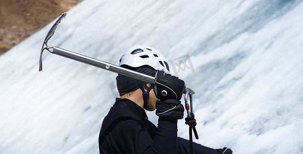 男子正在冰川上用冰斧攀登。