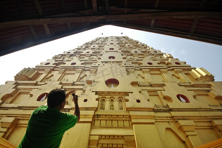 一名男子为 W 的 Sangkhlaburi 寺金顶拍摄照片