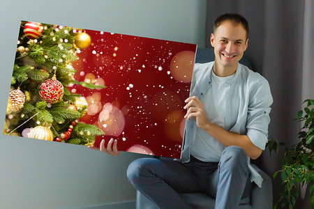 一个男人拿着一张印有圣诞节照片的画布