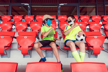 covid-19期间足球场里的两个男孩戴着口罩