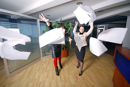 两个女商人往办公室扔文件