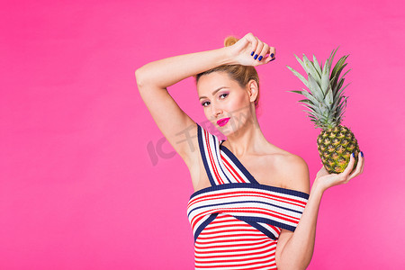 有趣的女人和菠萝在粉红色背景与 copyspace 的画像。