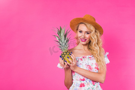 幸福的女人和菠萝在粉红色背景与 copyspace 的画像。
