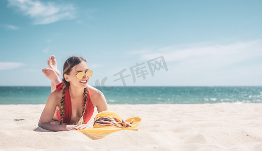 在沙滩上晒黑的海边享受假期的女人