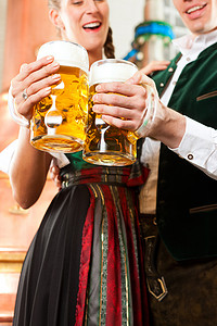 啤酒厂里拿着啤酒杯的男人和女人