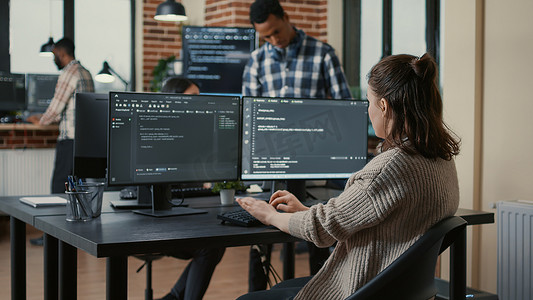 专注的软件开发人员在多个计算机屏幕上编写代码