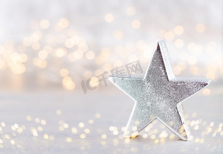 今日之星摄影照片_圣诞之星，散景银色背景上的装饰。