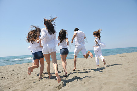 快乐的人团体在沙滩上玩得开心和奔跑