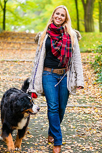 在公园里用皮带遛狗的女人