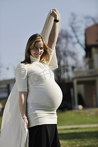 孕妇户外摄影照片_快乐的年轻孕妇户外