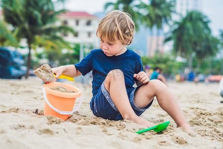 孩子用孩子们的铲子和水桶在沙滩上玩耍