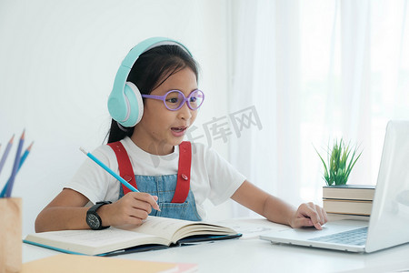 漂亮时尚的女学生在家上网课学习作业，学习在线视频通话老师。