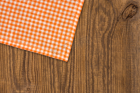 桌布格子摄影照片_质朴的木板，配有橙色格子桌布