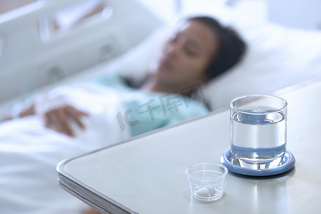 病人感冒了躺在床上睡觉，里面有药物和水