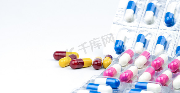 白色背景上彩色抗生素胶囊药丸，抗菌药物耐药性与复制空间。