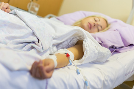 康复护理摄影照片_卧床不起的女性患者在医院护理中手术后康复。