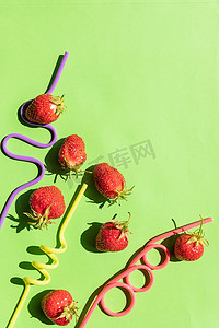 邀请函创意摄影照片_创意布局草莓柠檬水配料。绿色背景上的鸡尾酒吸管。