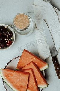 质感极简摄影照片_一堆夏天和新鲜水果放在极简主义的白色桌子上，西瓜和樱桃，健康和健康的食物概念，美味，有质感，复制空间