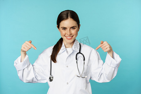 微笑的医生医务人员，用手指指着标志，诊所横幅，展示广告，穿着白大褂，绿松石背景