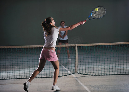网球摄影照片_年轻女孩在室内打网球比赛