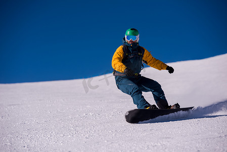 冬天骑行摄影照片_滑雪者跑下斜坡并自由骑行