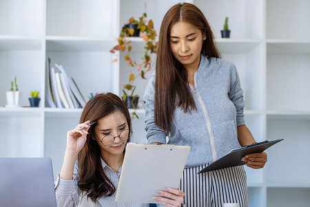 季度报告摄影照片_女企业家和同事们正在使用预算文件来计算当年最后一个季度的收入，以规划来年的金融投资。