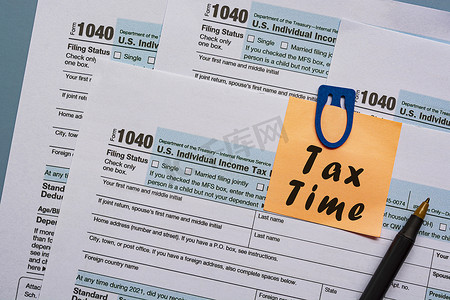 税表 1040。桌上的美国个人所得税申报表，记事本上有文字