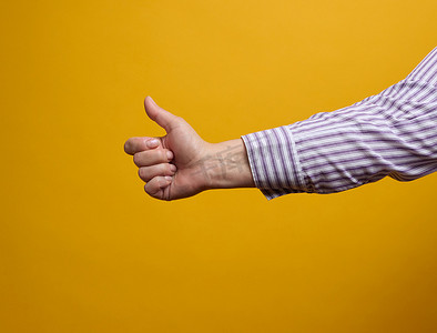 黄色手指手势摄影照片_女性的手在黄色背景上表现得像手势。
