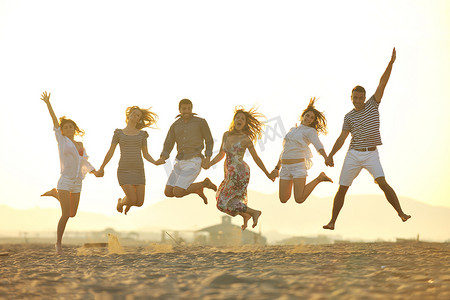 快乐的年轻人团体在沙滩上玩得开心