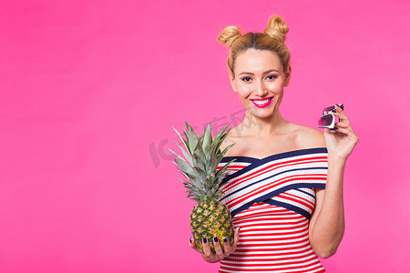 粉色菠萝摄影照片_粉色背景、带墨镜和菠萝的时尚肖像女性，带复制空间