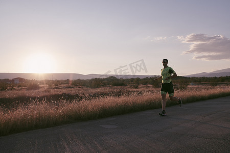 公路跑步摄影照片_晨练中跑步的铁人三项运动员