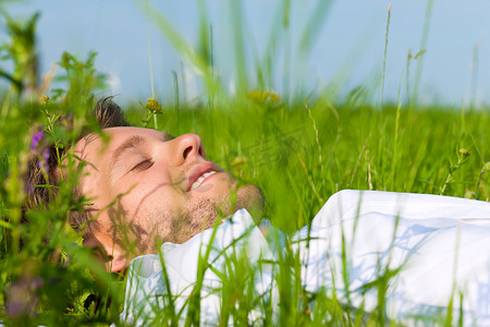 男人躺在草坪上做梦